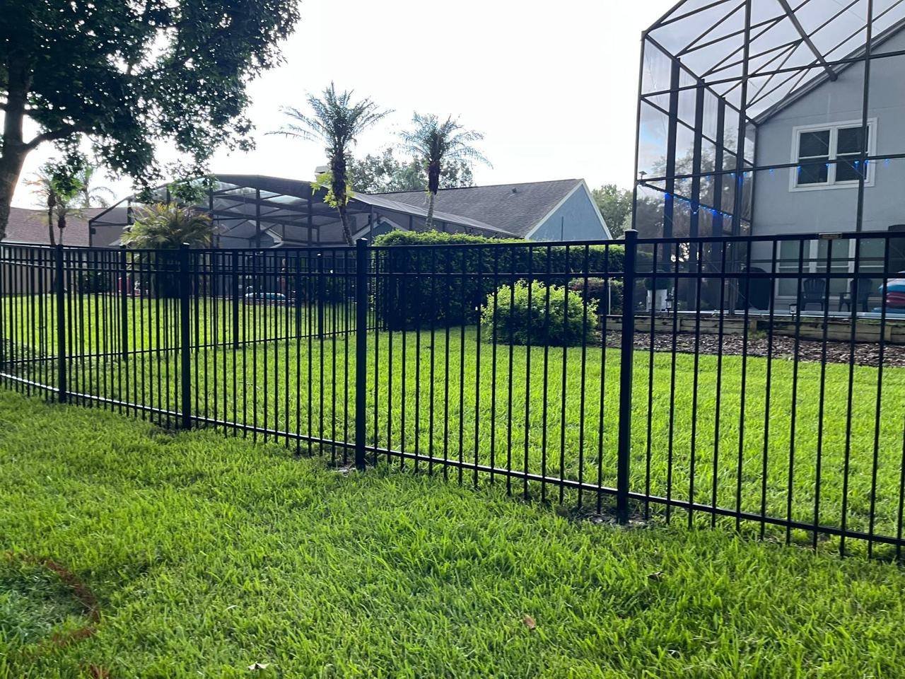 Black aluminum fence near a screened pool enclosure