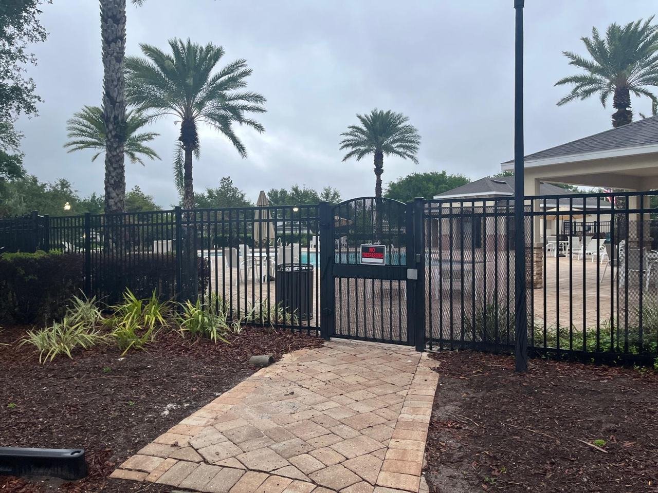 Black aluminum pool fence with gate around a community pool in Florida