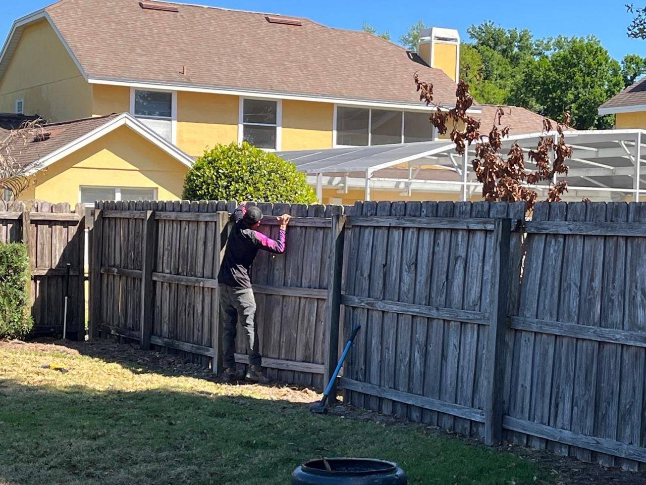 Old wood fence being removed before new fence installation